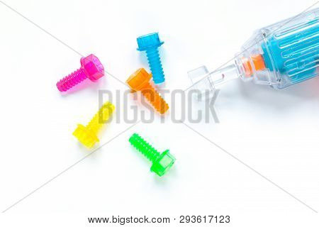 Colored Neon Translucent Plastic Toy Bolts And Screwdriver On White Background. Concept World Dad's 