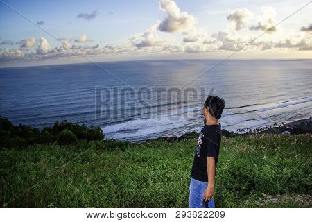 A Man Standing And Pointing At The Sea On Paragliding Hill Watugupit At Yogyakarta. Yogyakarta, Indo