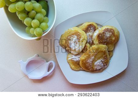 Traditional Polish Pancakes On A Plate And Green Grapes - Sweet Pancakes Sprinkled With Powdered Sug