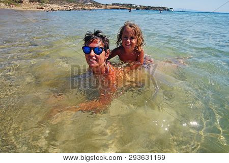 Two Tourists Take A Bath In Farangas Beach, Paros, Greece