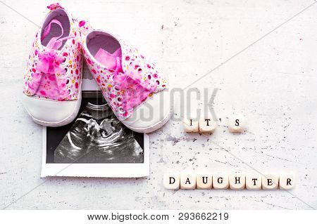 Pink Baby Booties With A Picture Of Ultrasound For Twenty Weeks On A Light Background. Inscription I