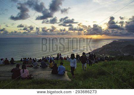 Yogyakarta, Indonesia - April 2, 2019 People Sitting On The Ground And Watch For Sun Set Paragliding