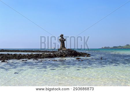 Jeju Island, South Korea, September 10, 2015: Statue Of Fisherman Made Of Lava Rock With Clear Blue 