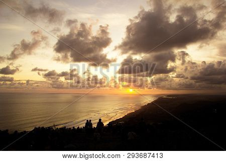 People Sitting On The Ground And Watch For Sun Set Paragliding Hill Watugupit At Yogyakarta
