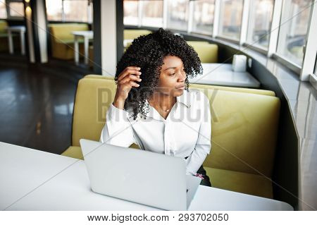 Сheerful Business African American Lady With Afro Hair, Wear White Blouse Sitting At Table And Work