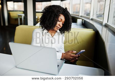 Сheerful Business African American Lady With Afro Hair, Wear White Blouse Sitting At Table And Work