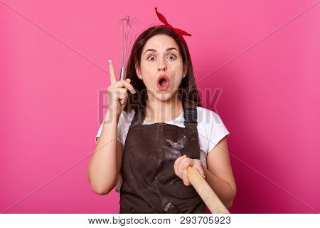 A Portrait Of Enthusiastic Energetic Baker Holding Whisk And Rolling Pin In Her Hands, Looks Creativ