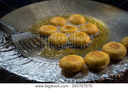 Potato Pancakes Frizzle In Black Frying Pan. Potato Pancakes Fried In Boiling Oil. Street Food In In