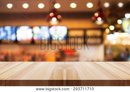 Empty Wooden Table Top With Blurred Coffee Shop Or Restaurant Interior Background. Abstract Backgrou