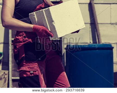 Unrecognizable Woman Working On Construction Site, Building House, Installing Gray Airbricks. Indust