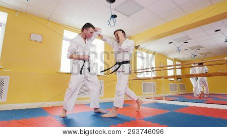Two Athletic Men Training Their Aikido Skills In The Studio.