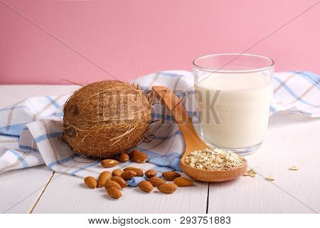 Assortment Of Organic Vegan Non Dairy Milk From Nuts In Glass On A Wooden Table On Pink Background. 