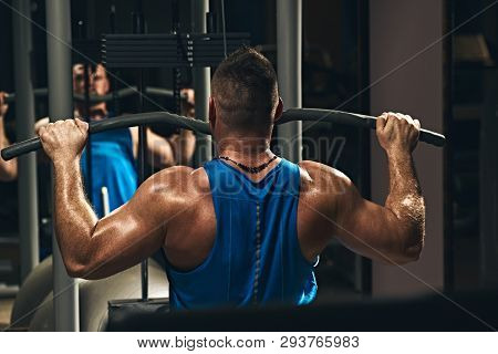 Strong Male Bodybuilder Doing Exercise For Back With Lat Pulldown Machine In Gym
