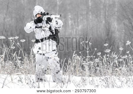 Man Soldier In The Winter On A Hunt With A Sniper Rifle In White Winter Camouflage Aiming Standing I