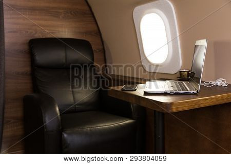 Laptop On The Table In The Interior Of A Private Jet. Flying First Class.