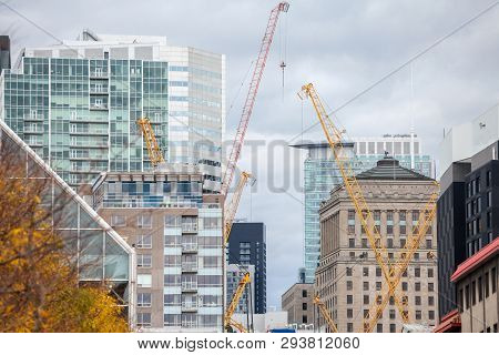 Cranes And Building Device On A Construction Site Of A Skyscraper In Downtown Montreal, Surrounded B