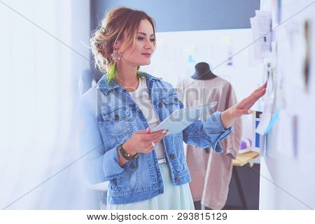 Fashion Designer Woman Working On Her Designs With Ipad In The Studio