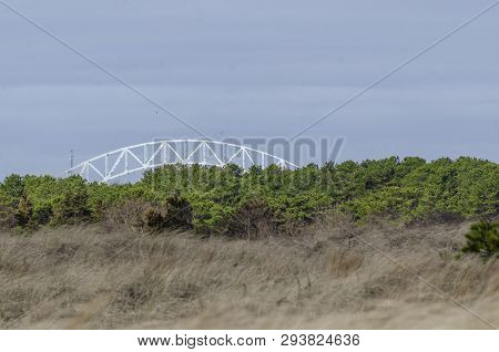Arch Of Sagamore Bridge Over Cape Cod Canal Serves As Background To Blur Of Beach Grass And Shrubs B