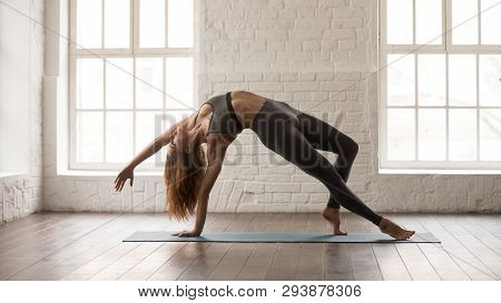 Young Woman Practicing Yoga, Standing In Wild Thing Pose, Camatkarasana