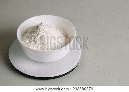 Flour In A Bowl Is On A Kitchen Scale.