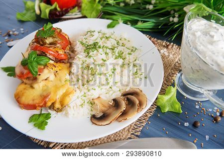 Chicken Fillet Baked In Cheese With Rice And Vegetables. Fired Cordon Bleu Chicken Served With Rice 