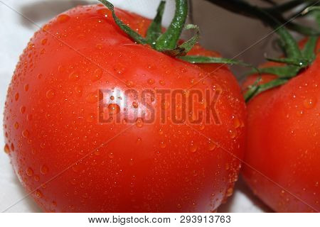 Two Red Tomatoes Close Up On A White Background Lie