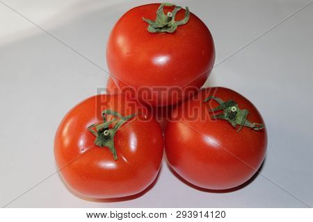 Three Red Juicy Tomato Lying On Light Background