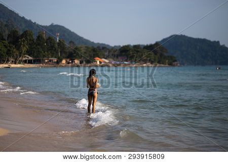 Ko Chang, Thailand - April 9, 2018: Genuine Asian Thay Girl Walking Along The Sea On A Beach With Am