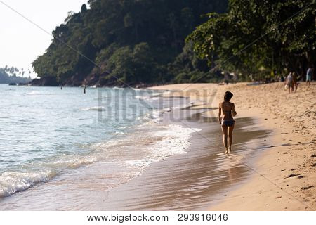 Ko Chang, Thailand - April 9, 2018: Genuine Asian Thay Girl Walking Along The Sea On A Beach With Am