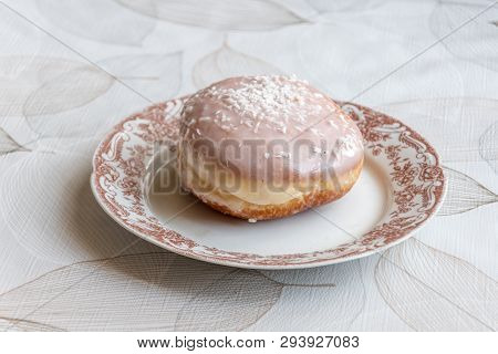 Traditional Polish Donut Known As Paczek. Paczek With Frosting With Coconut Flakes.