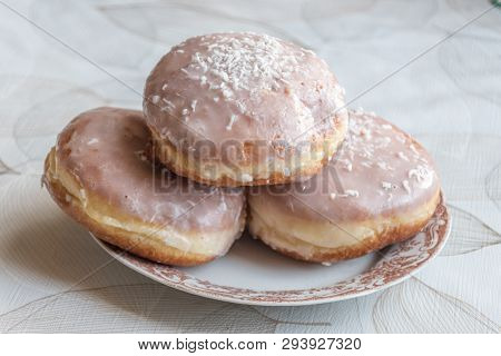 Traditional Polish Donuts Known As Paczeki. Paczeks With Frosting With Coconut Flakes On The Top.