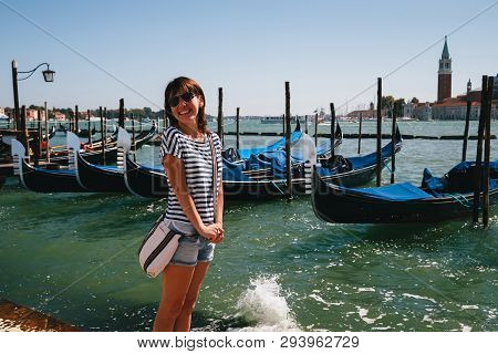 Young Woman Tourist Standing In Front Of The Gondolas At Traghetto Molo Near To The San Marco Square