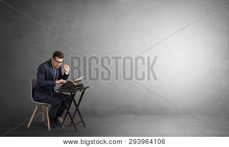 Man working hard on a typewriter in an empty space