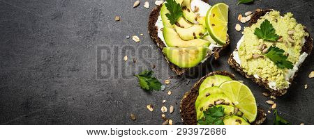 Sandwiches With Avocado And Cream Cheese With Grain Bread And Seeds. Black Slate Background, Top Vie