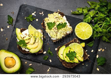 Avocado Sandwich With Seeds And Cream Cheese. Black Slate Background, Top View.
