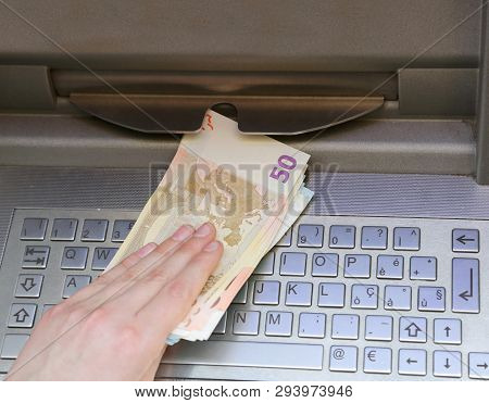 Hand That Withdraws Banknotes Of 50 Euros From An Atm Of A European Bank