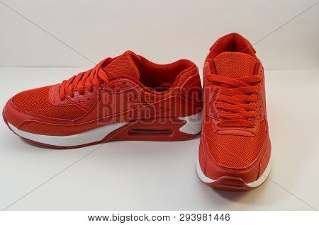 Red Sneakers With White Sole On A White Background, Close-up