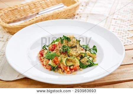 An easy, zesty summer salad with a Mediterranean flair featuring Israeli couscous and chopped summer vegetables