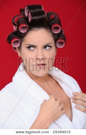 En brunette i morgen med hairroller på.