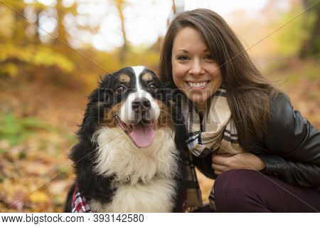 Cute Girl With Her Dog In Autumn Park. Bernese Mountain Dog