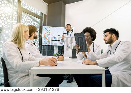 Multiethnic Five Doctors Having A Discussion During The Meeting At Conference Room, Using Tablets An