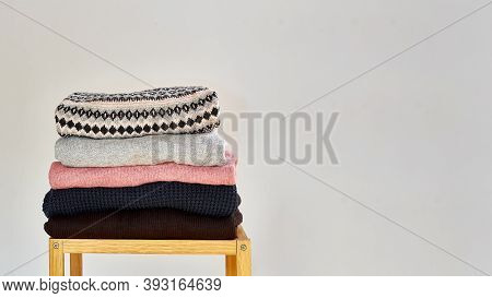 Autumn Winter Season Knitwear. A Stack Of Warm Knitted Sweaters With Different Knitting Patterns On 