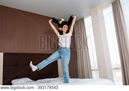 Happy Epressions. A Young Woman Is Having Fun With A Stuffed Panda In Her Hand, Holding It Up. Indoo