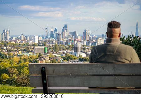 London, Uk - October 5, 2020 - A Man Sitting On Bench While Viewing London City Skyline From Parliam