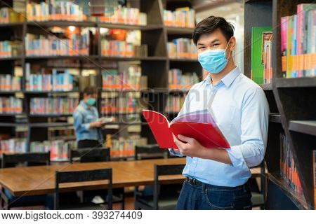 Two Asian University Students Wearing Face Mask And Standing In Library Social Distance From Other 6
