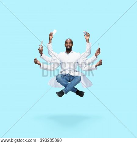 Handsome African Doctor, Multi-armed Man Levitating Isolated On Blue Studio Background With Equipmen