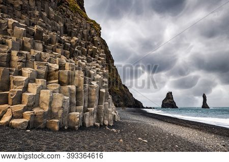 Incredible view on Black beach and Troll toes cliffs in cloudy weather. Stormy sky with menacing mammatus clouds on background. Reynisdrangar, Vik, Iceland. Landscape photography