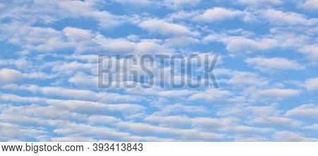 Beautiful Mottled Sky Background Showing White Fluffy Clouds Against Blue Sky