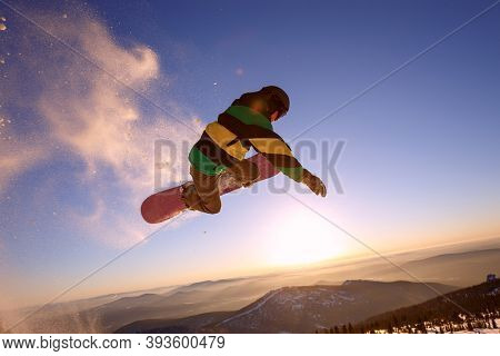 Snowboarder jumping through air with deep blue sky in background