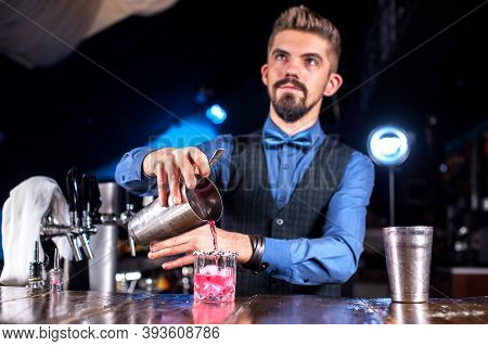 Charismatic Female Bartender Decorates Colorful Concoction At The Nightclub